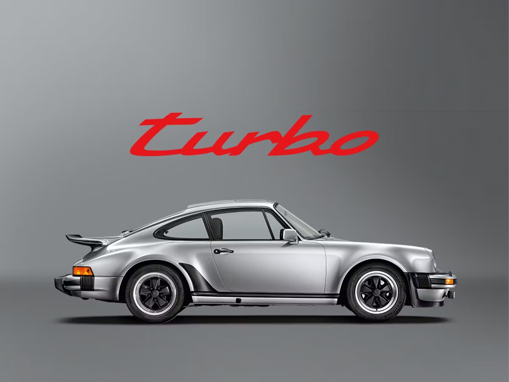 Grey historic Porsche 911 Turbo on a grey background with a red lettering turbo 